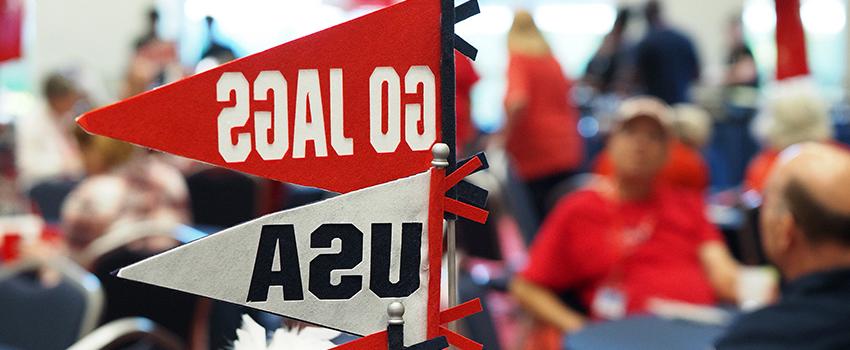 Go Jags and USA pennants on table at tailgate event.